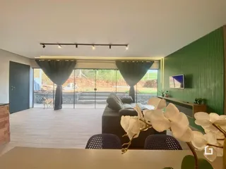 Sala de estar com piso de madeira e portas de vidro que dão acesso ao exterior.