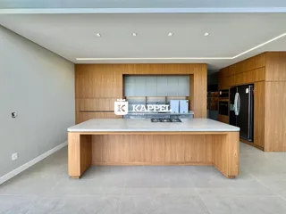 Foto de uma cozinha moderna com ilha central e armários de madeira.