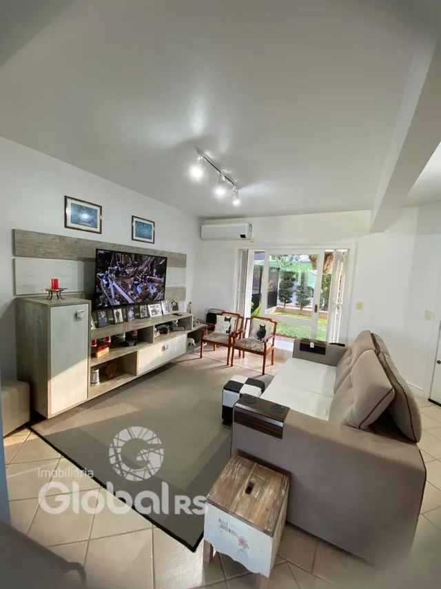 Sala de estar com sofá e televisão em ambiente interno.