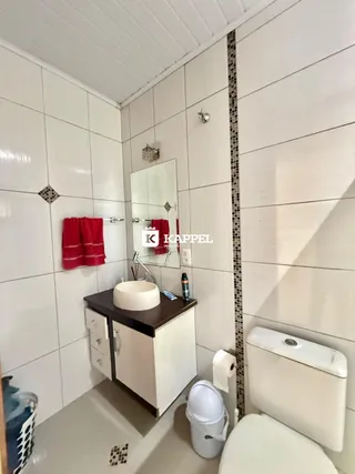 Foto de um banheiro com revestimento branco e bancada.