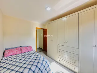 Quarto com armário embutido e cama em um imóvel em Lajeado.