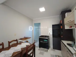 Ambiente interno com mesa de madeira e paredes brancas.