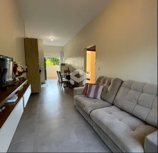 Sala de estar com sofá e piso de cerâmica em uma residência.
