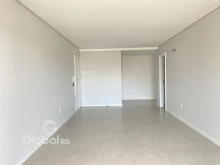 Hall de entrada de uma residência com paredes brancas e piso claro.