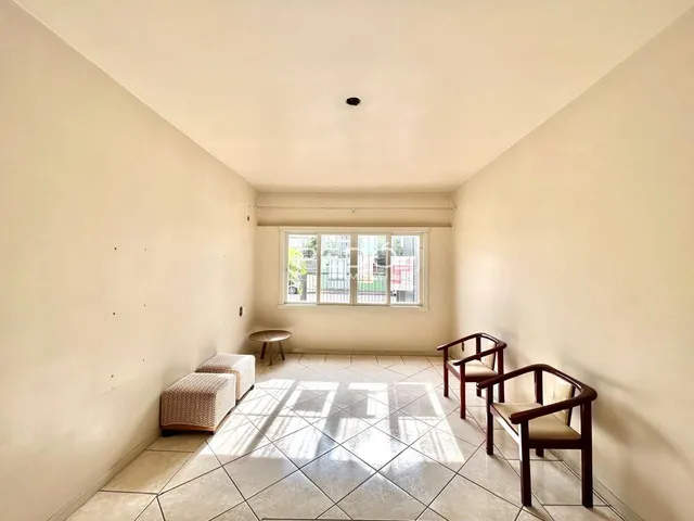 Sala de estar com piso de cerâmica e móveis de madeira clara.