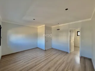 Ambiente interno de uma sala com piso de madeira clara.