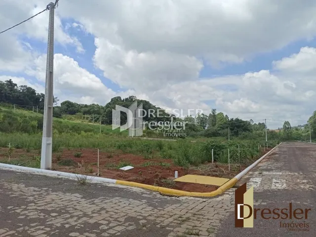 Vista externa de uma propriedade com cerca e vegetação ao ar livre.