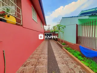 Vista externa mostrando um caminho pavimentado entre duas edificações em Lajeado.