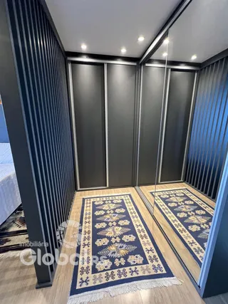 Hall de entrada com paredes escuras e piso de madeira na residência.