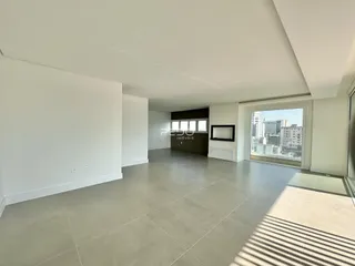 Sala ampla com piso de cerâmica e vista para a cidade.