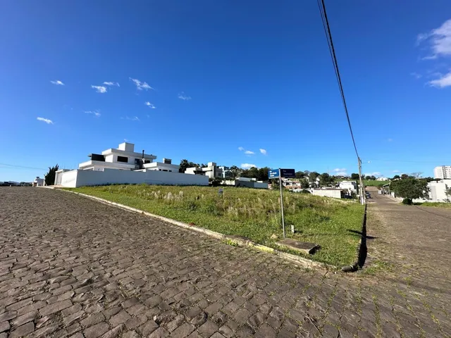 Vista externa de uma propriedade com área gramada e céu azul.