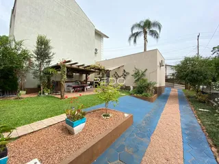 Vista externa de uma residência com jardim e área de lazer.