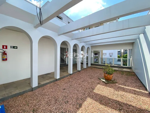 Vista da área comum de um pátio coberto com paredes em arco em um imóvel.