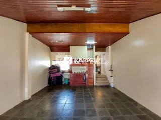 Hall de entrada com forro de madeira e piso de cerâmica escura.