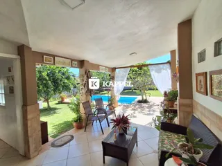 Sala de estar com vista para um jardim e piscina externa.