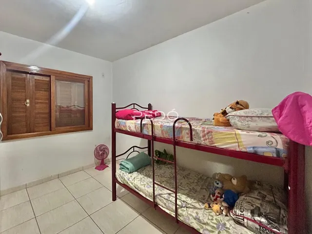 Quarto com cama e armário de madeira no interior da residência.