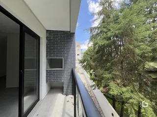 Vista de um apartamento com varanda e vegetação.