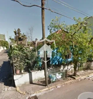 Vista externa de uma propriedade com vegetação e postes na Lajeado.