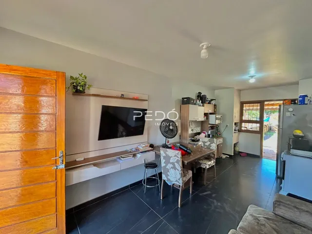 Sala de estar com móveis de madeira e televisão em um apartamento.