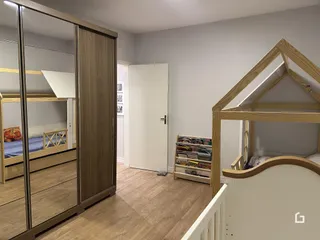 Quarto com cama de beliche e armário de madeira em um imóvel no Brasil.