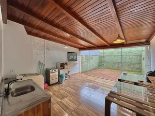 Interior de uma sala com piso de madeira e teto de madeira.