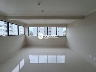 Ambiente amplo com grandes janelas que oferecem vista para o exterior.