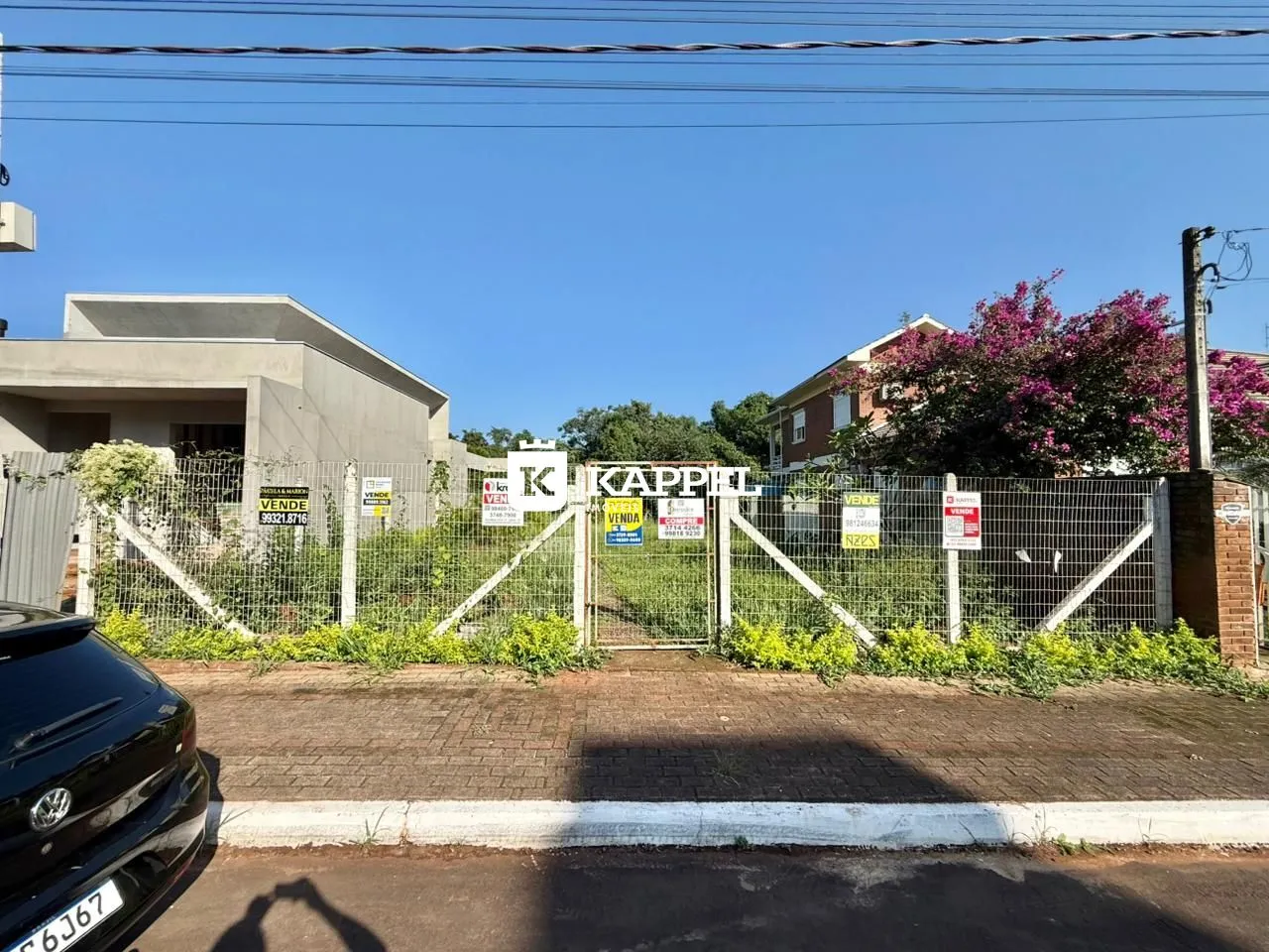 Foto da fachada de uma residência em Lajeado, Brasil, com cerca e vegetação ao fundo.
