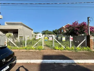 Foto da fachada de uma residência em Lajeado, Brasil, com cerca e vegetação ao fundo.