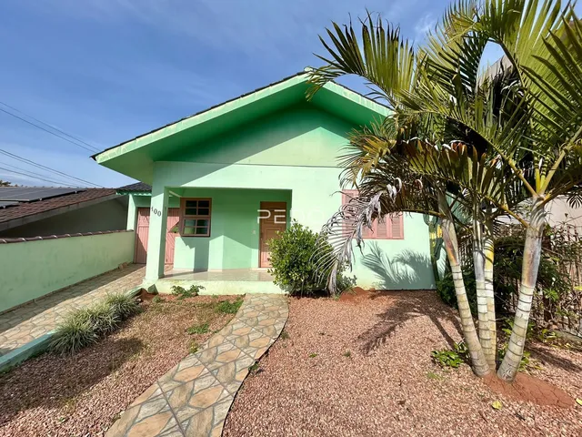 Fachada de uma casa em Lajeado, Brasil, com jardim e palmeiras.