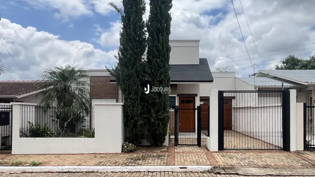 Fachada de uma residência em Lajeado, Brasil, com cerca e portão de ferro.