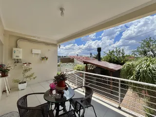 Vista da varanda com grade de segurança e vegetação.