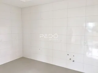 Parede branca e piso claro de um imóvel.