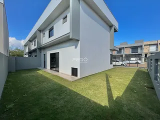 Fachada de uma residência moderna com jardim gramado.