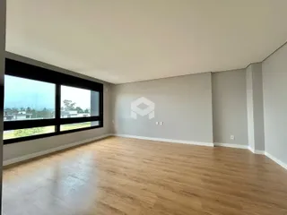 Sala com grande janela e piso de madeira.
