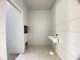 Foto interna de um banheiro com piso de cerâmica e paredes brancas.