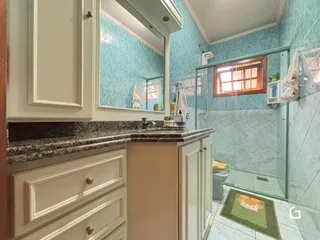 Foto de um banheiro com azulejos azuis e box de vidro.