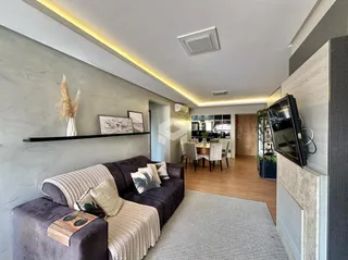 A sala de estar apresenta um sofá marrom e decoração moderna com iluminação em LED.