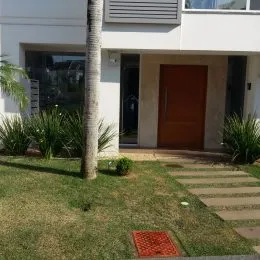 Fachada de uma residência branca com porta marrom em Lajeado, Brasil.