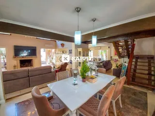 Sala de estar com sofá, lareira e mesa de jantar em um imóvel.