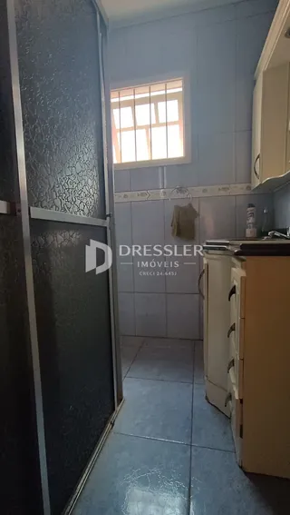 Interior de um corredor com piso de cerâmica e janela.