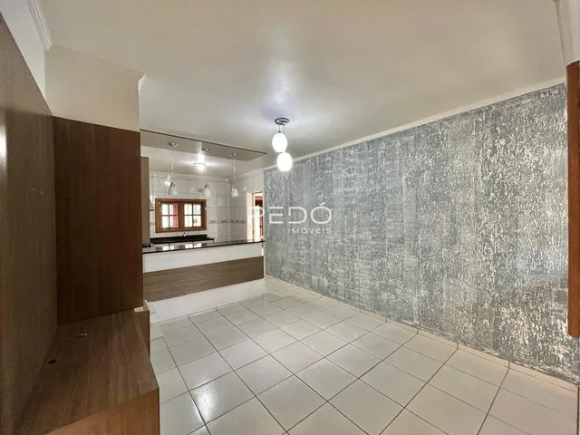 Interior de uma sala com piso de cerâmica e parede texturizada cinza.
