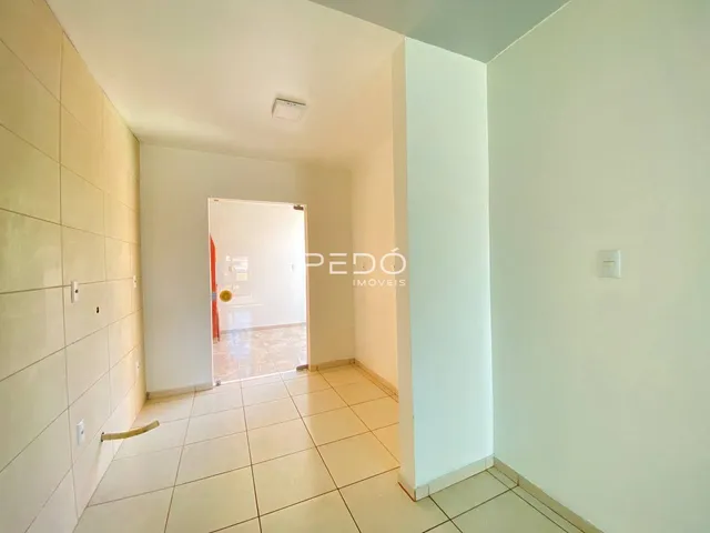 Hall de entrada com piso de cerâmica clara.