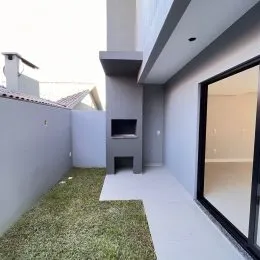 Vista da fachada de uma residência em Lajeado, Brasil, com piso claro e jardim frontal.