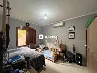 Quarto com cama de madeira e janela com persiana.