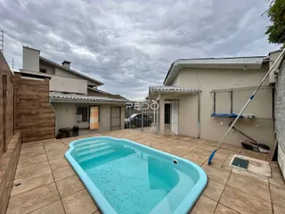 A foto mostra uma piscina externa em um pátio de uma residência.