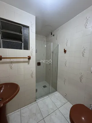 Foto interna de um banheiro com revestimento de cerâmica branca.