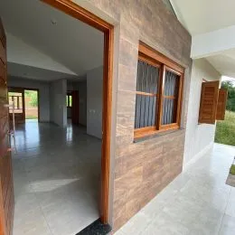 Hall de entrada com piso claro e paredes em tom terroso.