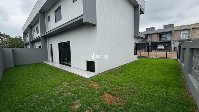 Fachada moderna de uma residência em Lajeado, Brasil, com jardim gramado.