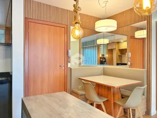 Ambiente interno de sala de jantar com painéis de madeira e espelho.