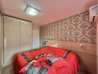 Quarto com cama vermelha e armários em madeira.